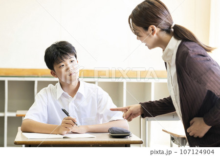 学校の教室で教わる生徒と教える先生 107124904