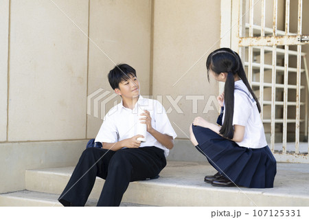 放課後の体育館に座る男子生徒と女子生徒 放課後の体育館に座る男子生徒と女子生徒 107125331