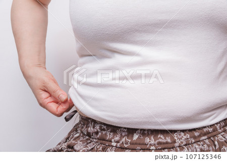 【お腹の肉を摘む主婦】 107125346