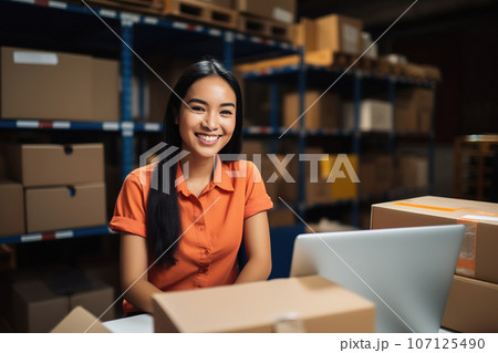 Asian female warehouse manager with laptop in distribution center. Storehouse package supervisor and shipment manager Asian female warehouse manager with laptop in distribution center. Storehouse package supervisor and shipment manager 107125490