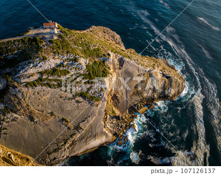 Aerial drone view of Cabo Espichel cape Espichel on Atlantic ocean at sunset with ruins 107126137