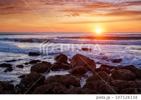 Atlantic ocean sunset with waves and rocks at Costa da Caparica, Portugal 107126138