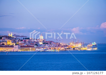View of Lisbon over Tagus river with moored cruise liner in evening twilight. Lisbon, Portugal View of Lisbon over Tagus river with moored cruise liner in evening twilight. Lisbon, Portugal 107126177