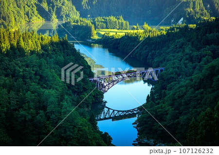 只見線　夏の第一只見川橋梁を渡る一番列車キハE120形(福島県三島町、8月中旬早朝) 107126232