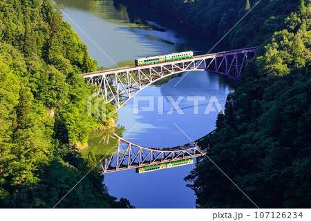 只見線　夏の第一只見川橋梁を渡る列車(福島県三島町、8月中旬早朝) 107126234