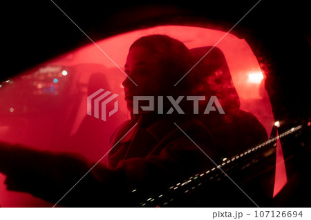 Serious businesswoman enjoying night drive while driving the red light background car  107126694