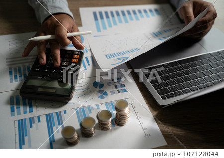 Business strategy of coins for finance business Economic money investment, professional businessman working marketing statistics analysis, and night cityscape 107128044