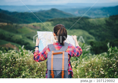Tourist woman looking a map while traveling on highland mountain in Chiang Rai province of Thailand. 107129002