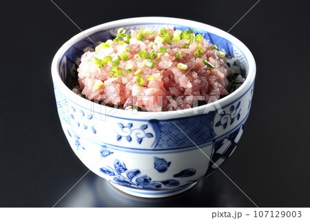 小葱が沢山乗っているマグロのたたき丼を黒背景で撮影 107129003
