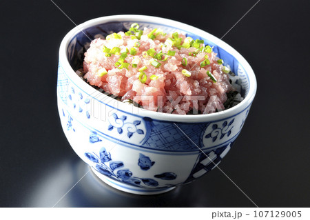 小葱が沢山乗っているマグロのたたき丼を黒背景で撮影 小葱が沢山乗っているマグロのたたき丼を黒背景で撮影 107129005