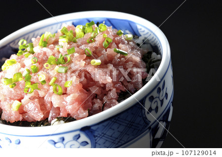小葱が沢山乗っているマグロのたたき丼を黒背景で撮影 107129014