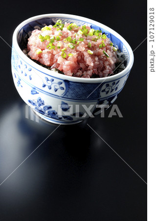 小葱が沢山乗っているマグロのたたき丼を黒背景で撮影 107129018
