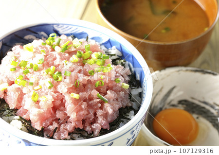 小葱が沢山乗っているマグロのたたき丼とお味噌汁と生卵 107129316