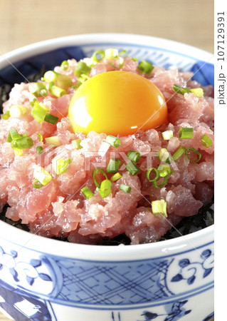 小葱と卵黄が乗っているマグロのたたき丼 107129391