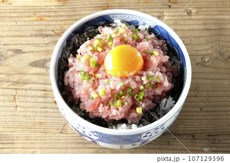 小葱と卵黄が乗っているマグロのたたき丼を俯瞰で撮影 107129396