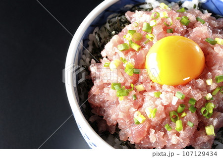 小葱と卵黄が乗っているマグロのたたき丼を黒背景で俯瞰撮影 小葱と卵黄が乗っているマグロのたたき丼を黒背景で俯瞰撮影 107129434