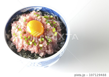 小葱と卵黄が乗っているマグロのたたき丼を白背景で俯瞰撮影 小葱と卵黄が乗っているマグロのたたき丼を白背景で俯瞰撮影 107129488