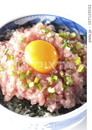 小葱と卵黄が乗っているマグロのたたき丼を白背景で俯瞰撮影 107129502