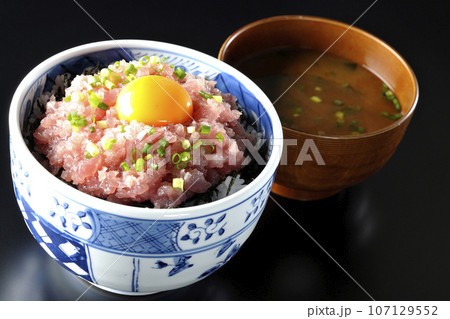 小葱と卵黄が乗っているマグロのたたき丼とお味噌汁 107129552