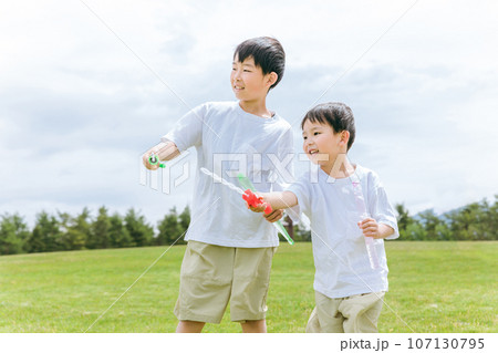 草原・公園でシャボン玉スティックで遊ぶ少年・兄弟・子供 107130795