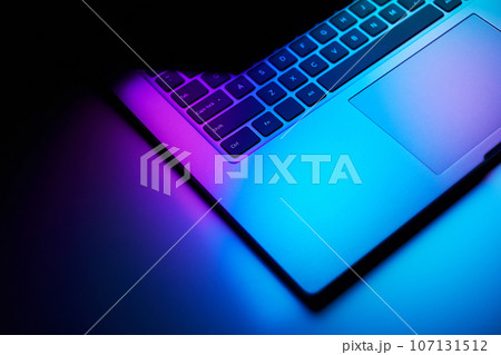 Close up image of laptop in dark neon light. Close up image of laptop in dark neon light. 107131512