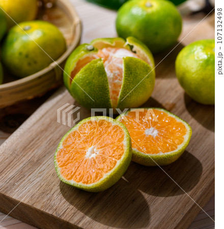 秋の味覚 とっても甘くておいしい早生みかん 温州みかん ( 青と黄色がまざりつつある蜜柑 ）早生蜜柑 107132498