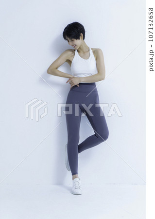 白背景のヨガウェアを着た若い女性のポートレート　縦位置 107132658