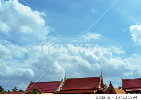 Atmosphere: bright blue sky and fluffy clouds On top of the roof of a temple church in Thailand Atmosphere: bright blue sky and fluffy clouds On top of the roof of a temple church in Thailand 107135594