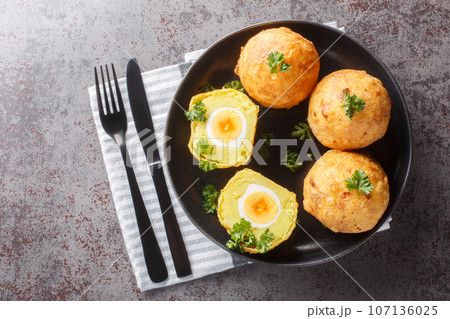 Guyanese cassava balls stuffed with boiled egg and then fried close up in a plate. Horizontal top view Guyanese cassava balls stuffed with boiled egg and then fried close up in a plate. Horizontal top view 107136025