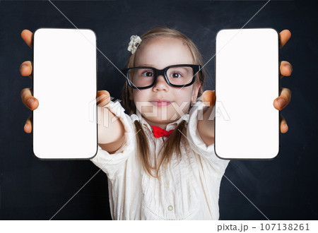 Happy girl in glasses holding smartphone with blank empty white screen display for new Application  107138261