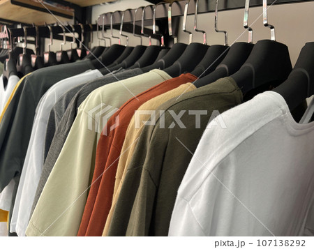 T-shirt hanging on hangers in the clothing store 107138292