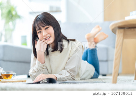 リビングでくつろぐ若い女性 リビングでくつろぐ若い女性 107139013