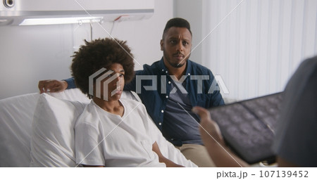 Doctor reports MRI scan results using tablet computer 107139452