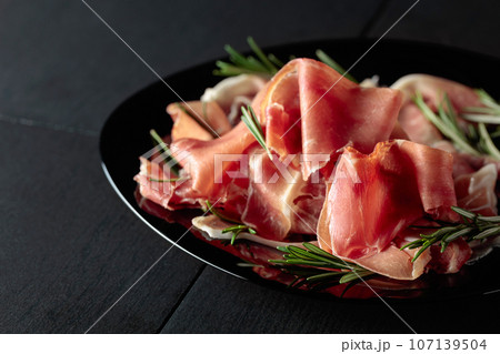 Italian prosciutto or Spanish jamon with rosemary. 107139504