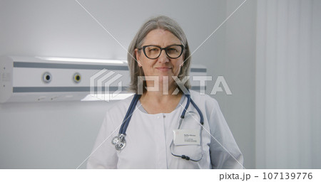 Medic with stethoscope stands in middle of hospital room Medic with stethoscope stands in middle of hospital room 107139776