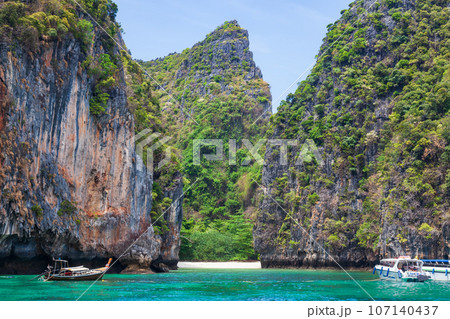 Pier or jetty on phi phi leh island in krabi in thailand near maya bay with boats and tourists on a hot sunny day. Travel and vacation. Pier or jetty on phi phi leh island in krabi in thailand near maya bay with boats and tourists on a hot sunny day. Travel and vacation. 107140437
