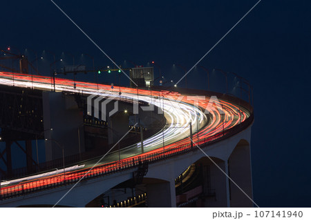 Blurred lights in motion from car headlights driving on a bridge in the night Blurred lights in motion from car headlights driving on a bridge in the night 107141940