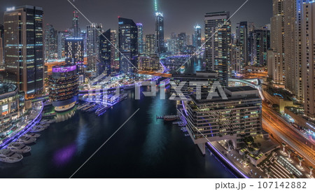Aerial view to Dubai marina skyscrapers around canal with floating boats night 107142882