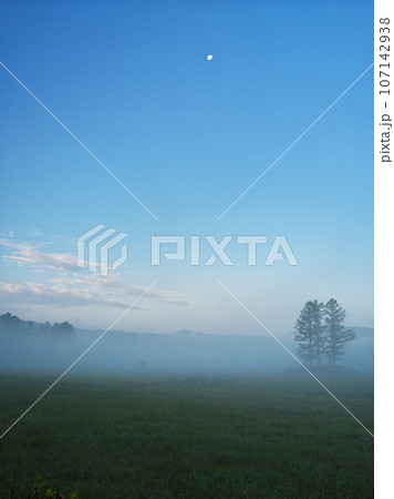 朝霧に包まれた夏の静かな尾瀬沼の大江湿原から月を臨む 107142938