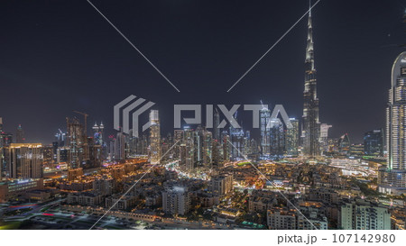 Panorama showing Dubai's business bay towers aerial night. Rooftop view of some skyscrapers 107142980