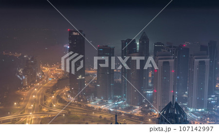 JLT and Dubai marina skyscrapers near Sheikh Zayed Road aerial all night. Residential buildings 107142997