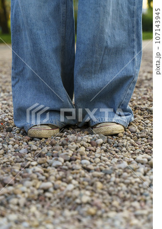 Teenager in vintage denim jeans and grunge sneakers. Street style, casual urban fashion Teenager in vintage denim jeans and grunge sneakers. Street style, casual urban fashion 107143945