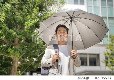 日傘をさした50代半ばのビジネスマン 日傘をさした50代半ばのビジネスマン 107145513