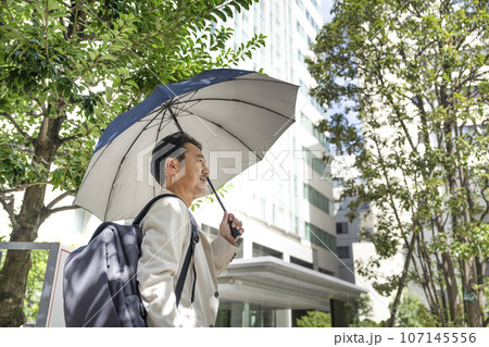 日傘をさした50代のビジネスマン 日傘をさした50代のビジネスマン 107145556