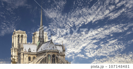 Notre Dame de Paris (against the background of sky with clouds), also known as Notre Dame Cathedral or simply Notre Dame, is a Gothic, Roman Catholic cathedral of Paris, France 107148481