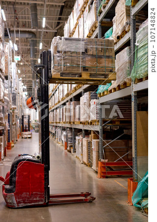 forklift loading shipment boxes goods on shelves in warehouse cargo storage 107148824