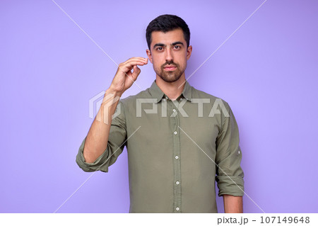 serious confident man in green shirt demonstrating letter D 107149648