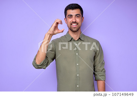 smiling deaf man wearing green shirt using sign language on blue background 107149649