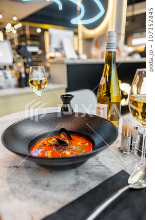 Tom yam in a black plate on a table in a restaurant 107152845