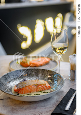 Salmon fillet in cream sauce with herbs on a marble table in a restaurant 107152846